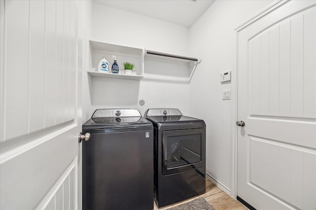 laundry area with separate washer and dryer and light wood-type flooring