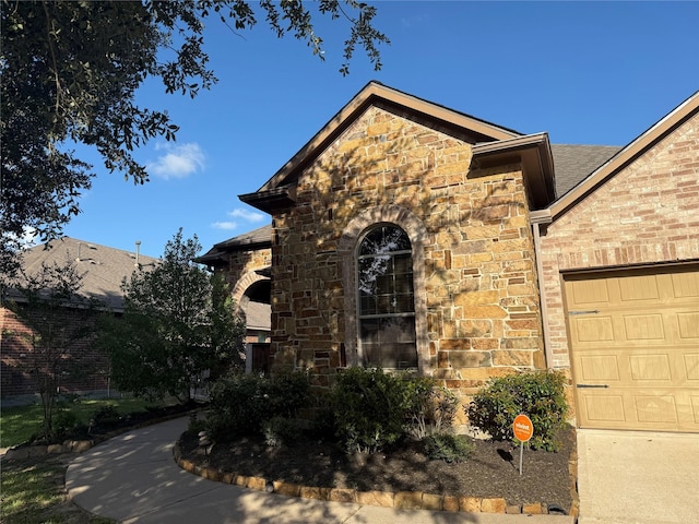 24211 Bella Florence Dr, Richmond, TX 77406 - view of home's exterior featuring stone siding, a garage, and brick siding