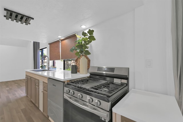 10731 Sageberry Dr, Houston, TX 77089 - kitchen with stainless steel appliances, a sink, light wood finished floors, light countertops, and recessed lighting