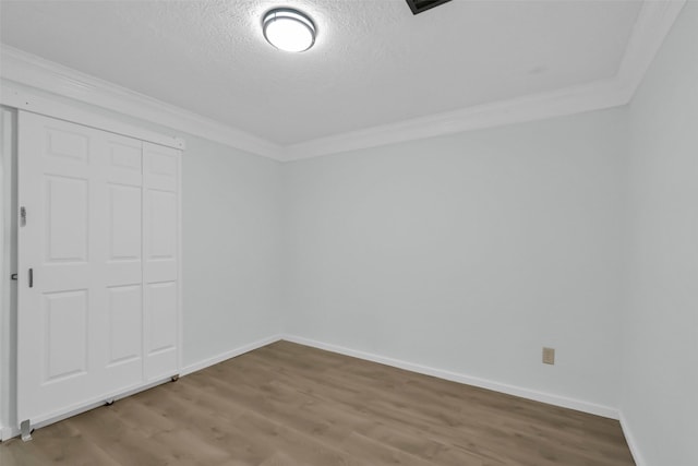 10731 Sageberry Dr, Houston, TX 77089 - unfurnished bedroom with wood finished floors, crown molding, a textured ceiling, baseboards, and a closet