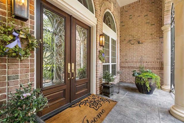 23303 Holly Creek Trl, Tomball, TX 77377 - doorway to property featuring french doors, brick siding, and covered porch