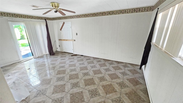 spare room featuring ceiling fan and baseboards