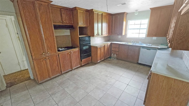 kitchen featuring brown cabinetry, black appliances, light tile patterned floors, a warming drawer, and light countertops