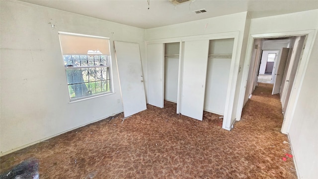 unfurnished bedroom featuring carpet flooring, multiple windows, and a closet