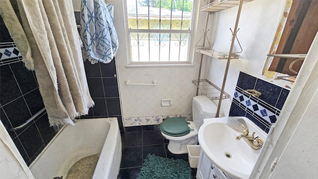 bathroom featuring healthy amount of natural light, toilet, vanity, tile walls, and tile patterned flooring