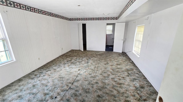 empty room with healthy amount of natural light and carpet
