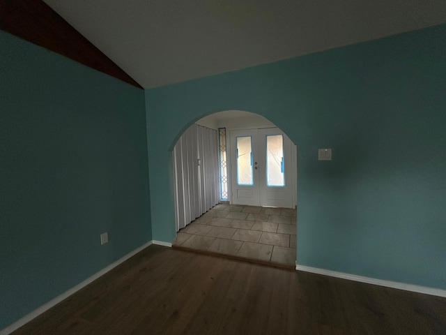 9974 Elder St, Willis, TX 77318 - unfurnished room with arched walkways, wood finished floors, baseboards, and lofted ceiling
