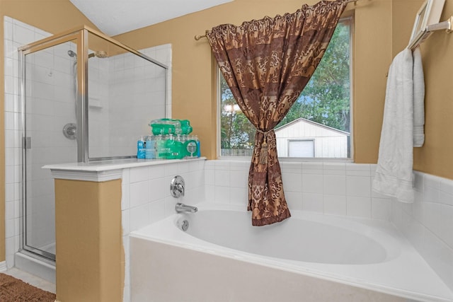 full bathroom with a stall shower, plenty of natural light, and a garden tub