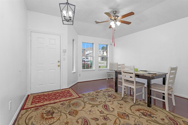 dining space with ceiling fan, a chandelier, baseboards, and wood finished floors