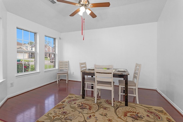 dining space with wood finished floors, a ceiling fan, and baseboards