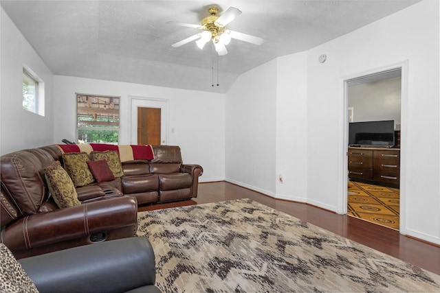 living area with dark wood finished floors, ceiling fan, lofted ceiling, and baseboards