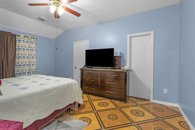 bedroom featuring light tile patterned flooring, vaulted ceiling, baseboards, and ceiling fan