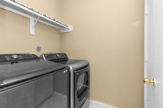 laundry area featuring washing machine and dryer and baseboards
