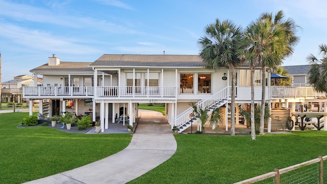 4321 Jolly Roger Rd, Galveston, TX 77554 - back of house featuring stairs, a shingled roof, and a yard