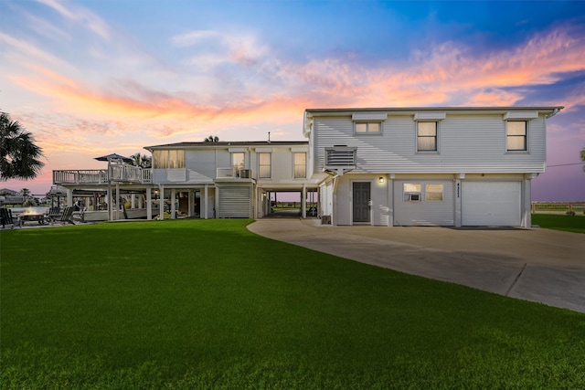 4321 Jolly Roger Rd, Galveston, TX 77554 - rear view of property with driveway, an attached garage, and a yard