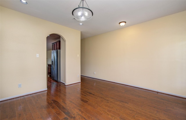 17607 Memorial Falls Dr, Tomball, TX 77375 - unfurnished room with arched walkways, wood finished floors, recessed lighting, and baseboards