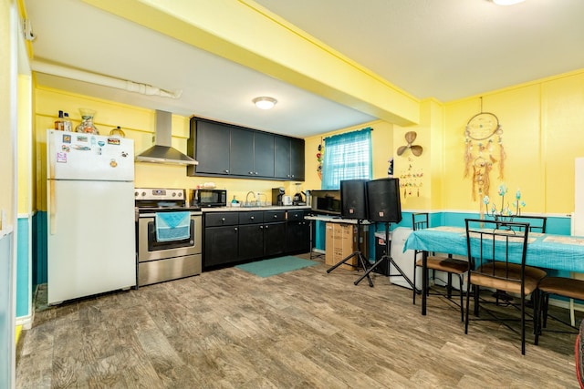 107 Crows Nest Rd, Freeport, TX 77541 - kitchen featuring stainless steel appliances, wall chimney exhaust hood, a sink, wood finished floors, and light countertops