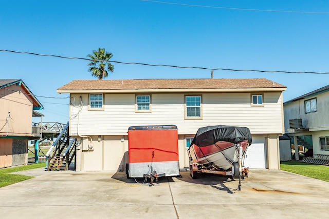 107 Crows Nest Rd, Freeport, TX 77541 - rear view of house with driveway, a garage, and stairs