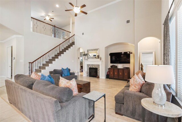 9612 Eden Ridge Ln, Pearland, TX 77584 - living area featuring a towering ceiling, a ceiling fan, arched walkways, stairway, and light wood-style flooring