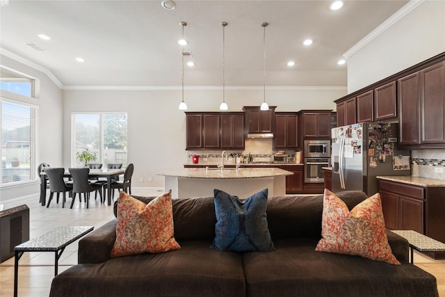 9612 Eden Ridge Ln, Pearland, TX 77584 - kitchen featuring appliances with stainless steel finishes, open floor plan, tasteful backsplash, dark brown cabinets, and an island with sink