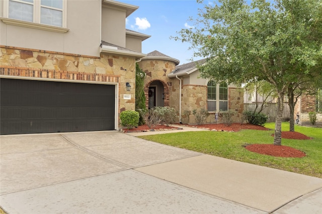 9612 Eden Ridge Ln, Pearland, TX 77584 - view of front of home with stone siding, a front lawn, a garage, stucco siding, and driveway