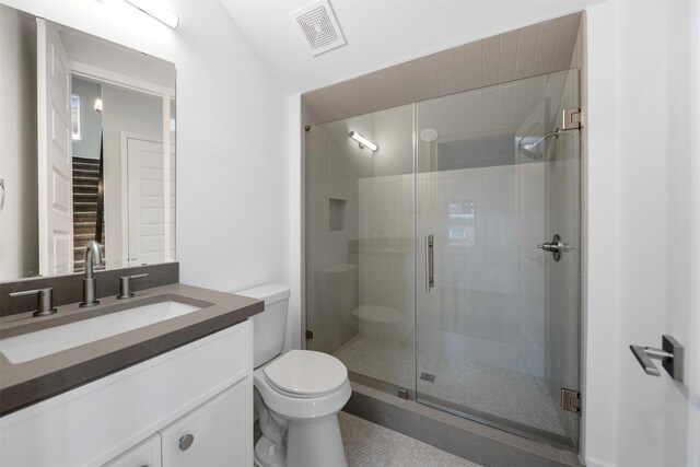 608 W Main St, Houston, TX 77006 - bathroom with toilet, vanity, a shower stall, and tile patterned floors