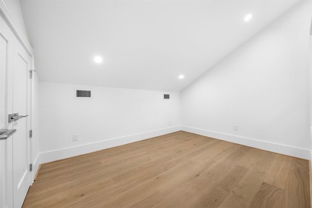 additional living space with lofted ceiling, baseboards, light wood finished floors, and recessed lighting
