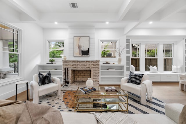 living room featuring plenty of natural light, recessed lighting, a brick fireplace, and wood finished floors