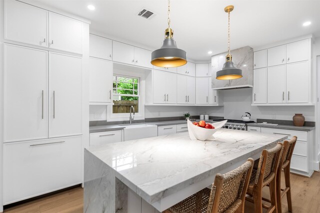 608 W Main St, Houston, TX 77006 - kitchen with a sink, light wood-type flooring, white cabinetry, and recessed lighting