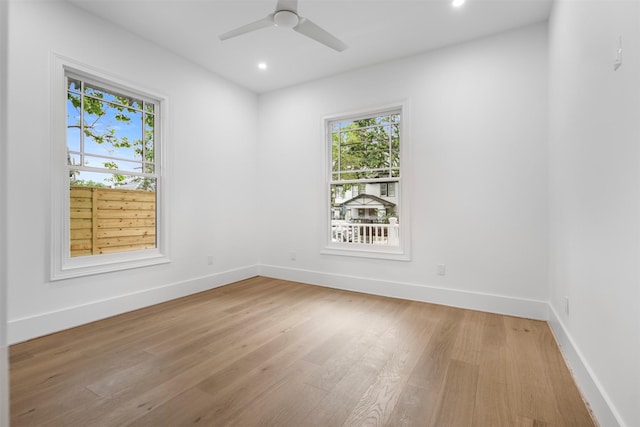 unfurnished room with plenty of natural light, baseboards, light wood finished floors, and recessed lighting