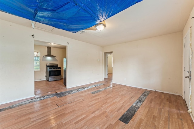 unfurnished living room with wood finished floors and baseboards