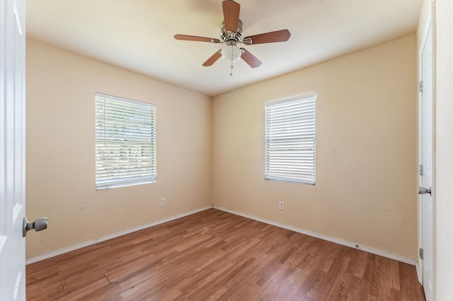 unfurnished room featuring wood finished floors, baseboards, and ceiling fan