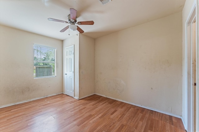 unfurnished room with wood finished floors, baseboards, and a ceiling fan