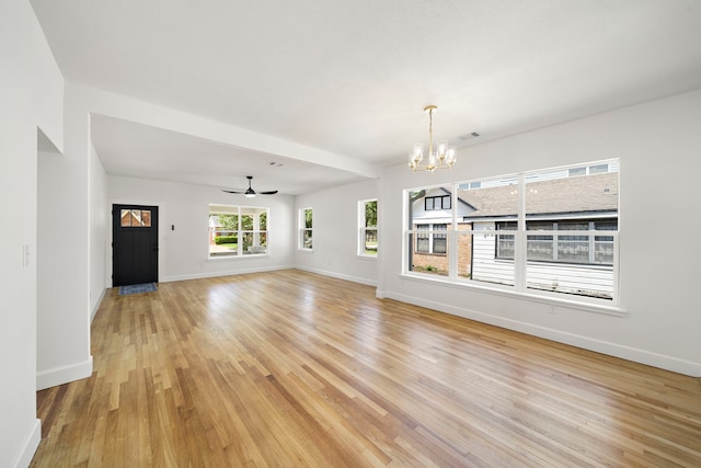 unfurnished living room with a chandelier, light wood-style flooring, baseboards, and a ceiling fan