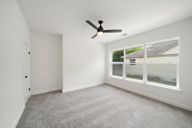 empty room featuring baseboards, carpet flooring, and ceiling fan
