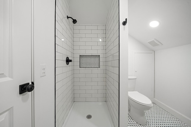 full bath with toilet, a tile shower, lofted ceiling, and baseboards