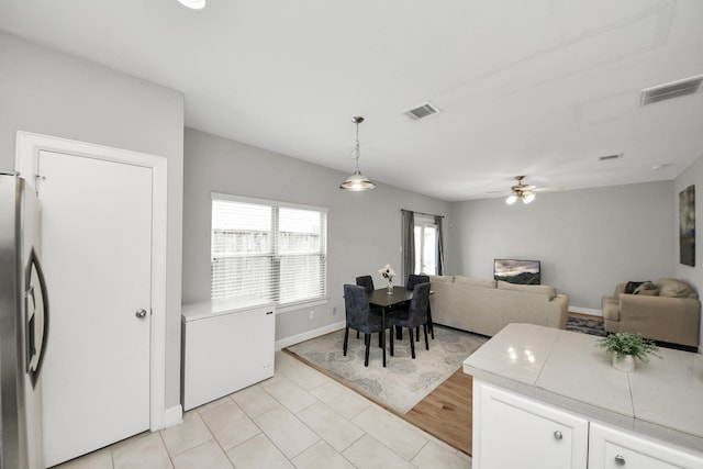3718 Main Poplar Dr, Houston, TX 77025 - kitchen with stainless steel fridge with ice dispenser, refrigerator, light countertops, pendant lighting, and ceiling fan