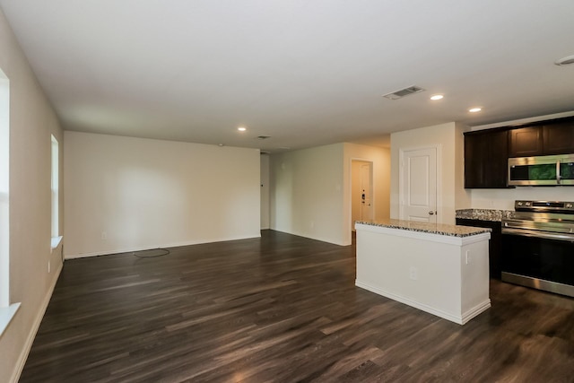 862 Rachel St, Houston, TX 77091 - kitchen with appliances with stainless steel finishes, recessed lighting, light stone counters, dark wood finished floors, and a kitchen island