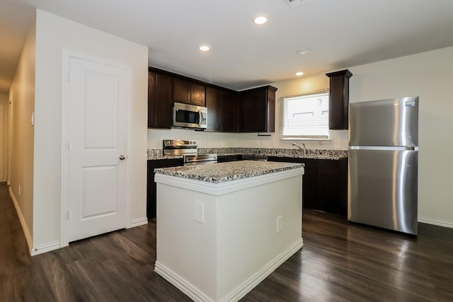 862 Rachel St, Houston, TX 77091 - kitchen featuring appliances with stainless steel finishes, dark brown cabinets, dark wood-style floors, a kitchen island, and recessed lighting