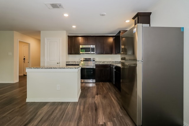 862 Rachel St, Houston, TX 77091 - kitchen with stainless steel appliances, dark wood finished floors, dark brown cabinetry, light stone counters, and a kitchen island