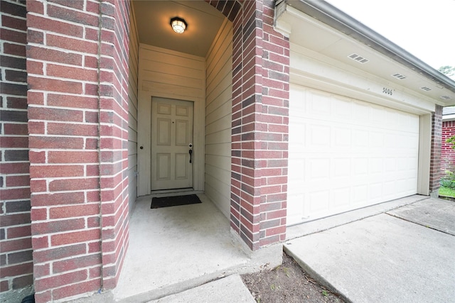 5006 Dawngate Dr, Spring, TX 77373 - view of exterior entry featuring a garage, brick siding, and driveway