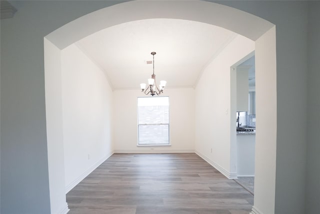 5006 Dawngate Dr, Spring, TX 77373 - unfurnished dining area with a chandelier, crown molding, wood finished floors, arched walkways, and baseboards