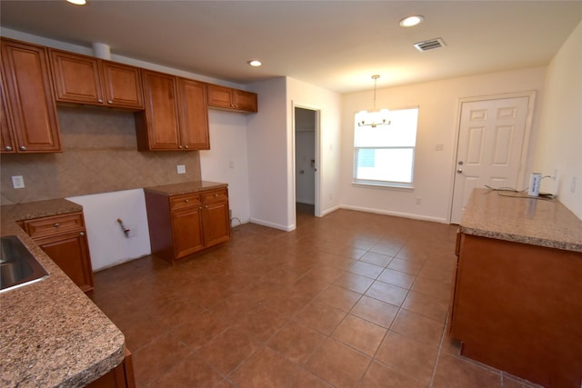kitchen featuring brown cabinetry, a chandelier, tasteful backsplash, recessed lighting, and hanging light fixtures