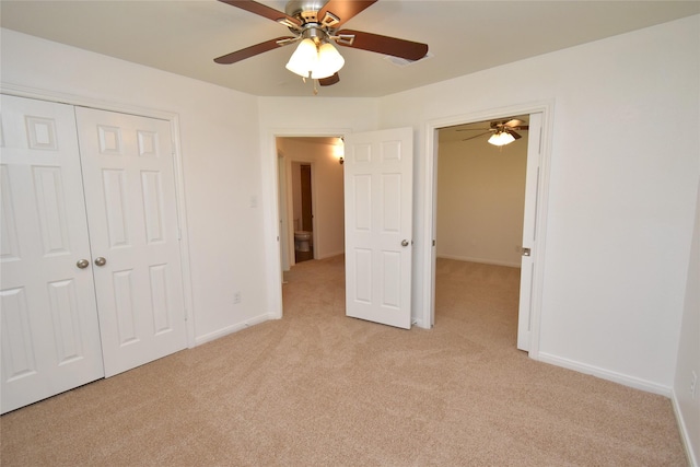 unfurnished bedroom with light colored carpet, a closet, baseboards, and a ceiling fan