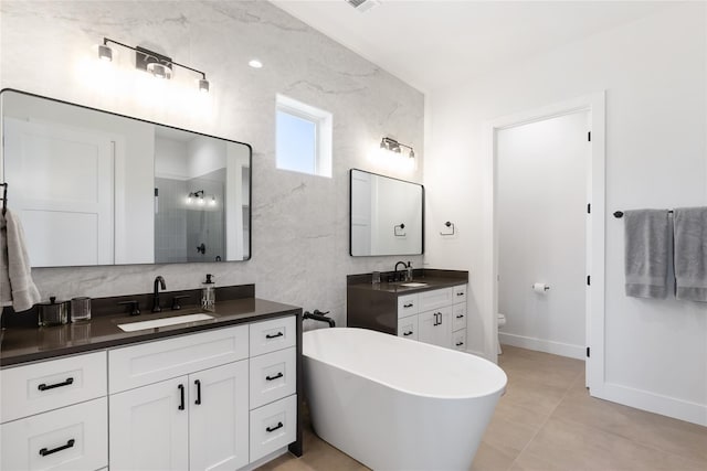 18605 Lakeland Dr, Point Venture, TX 78645 - bathroom with a stall shower, toilet, two vanities, baseboards, and a freestanding bath