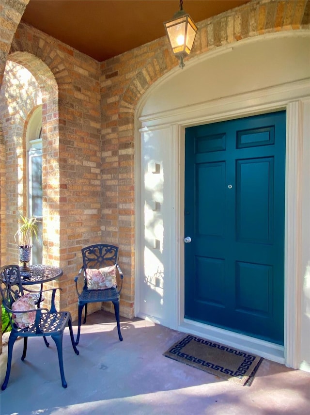 entrance to property featuring brick siding