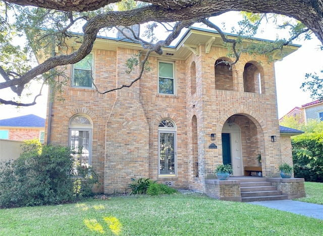 view of front of house with brick siding and a front yard