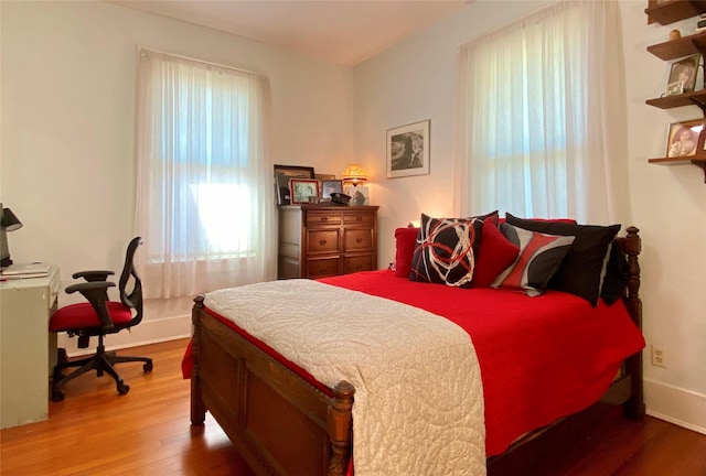 bedroom with wood finished floors and baseboards