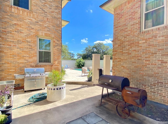 view of patio with a grill and fence