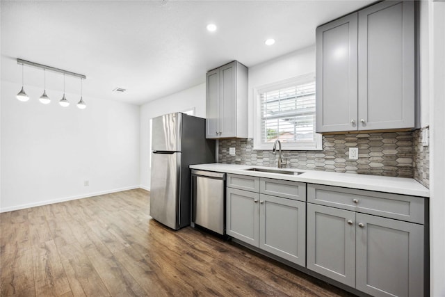 508 Kalmer St, Pasadena, TX 77502 - kitchen featuring gray cabinets, appliances with stainless steel finishes, a sink, decorative backsplash, and dark wood-style floors